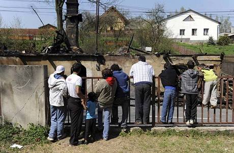 Místní obyvatelé pozorují práci hasi u domu ve Vítkov na Opavsku, kam neznámí pachatelé vhodili v noci na zápalné láhve. Pi následném poáru byli zranni ti lidé, mezi nimi dvouleté dít.